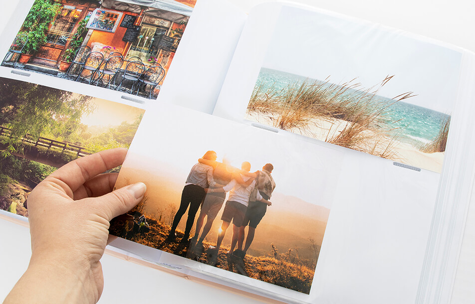 Öppet fotoalbum med plastfickor och foton